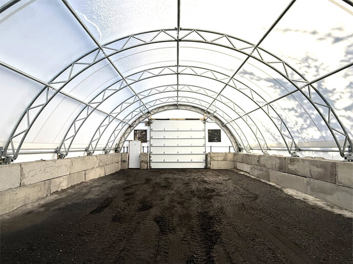 Intérieur d’un bâtiment en toile avec charpente d’acier galvanisé et murs de béton
