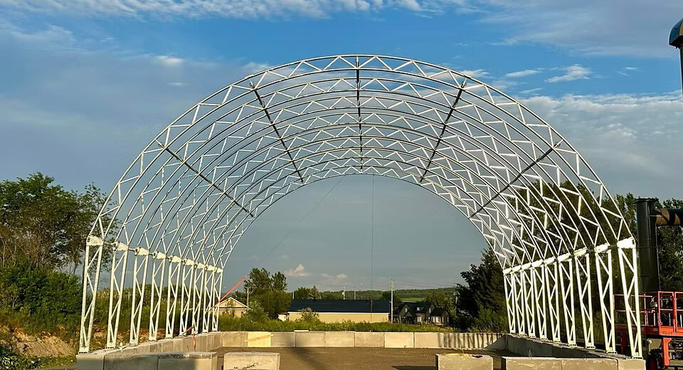 Charpente en acier galvanisé en cours d’installation pour un futur bâtiment en toile